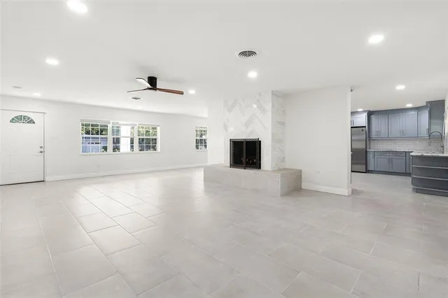 a view of empty room with a kitchen and fireplace