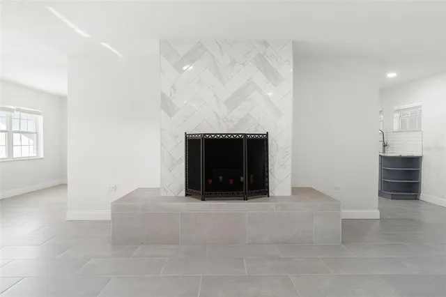 an empty room with fireplace and window