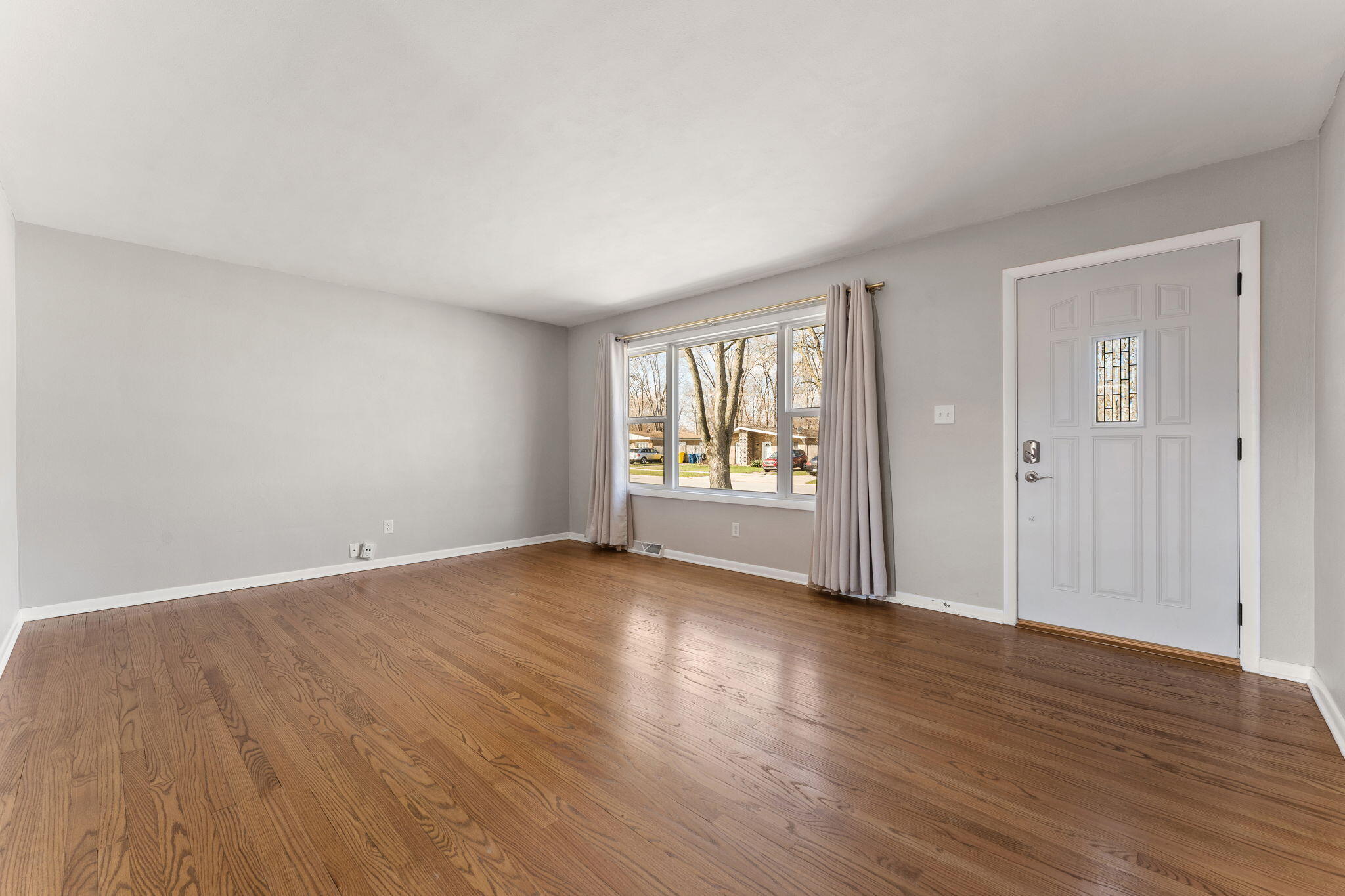 947 North Wood Street Griffith, IN 46319 - Photo 6 of 25 a view of an empty room with wooden floor and a window