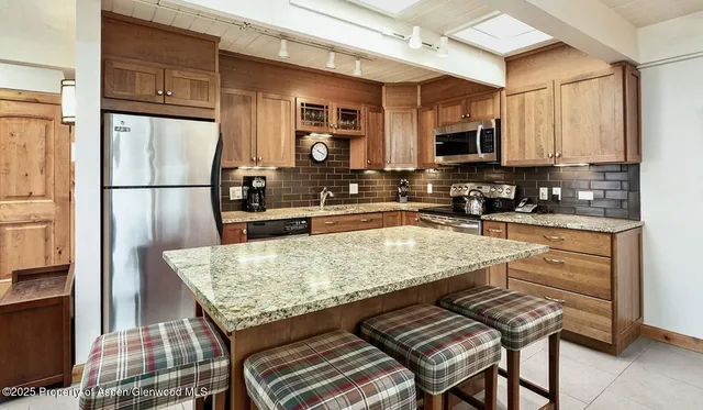 a kitchen with granite countertop a refrigerator stove and sink