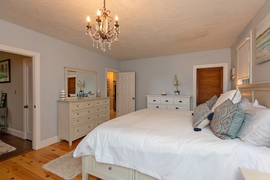 1193 Main Street, Unit A2 Hingham, MA 02043 - Photo 20 of 27 a spacious bedroom with a bed and a chandelier