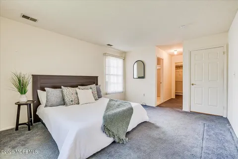 a spacious bedroom with a bed and a mirror