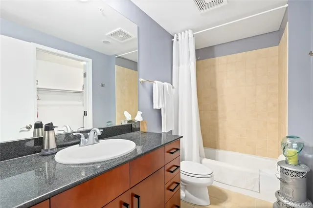 a bathroom with a double vanity sink toilet and mirror