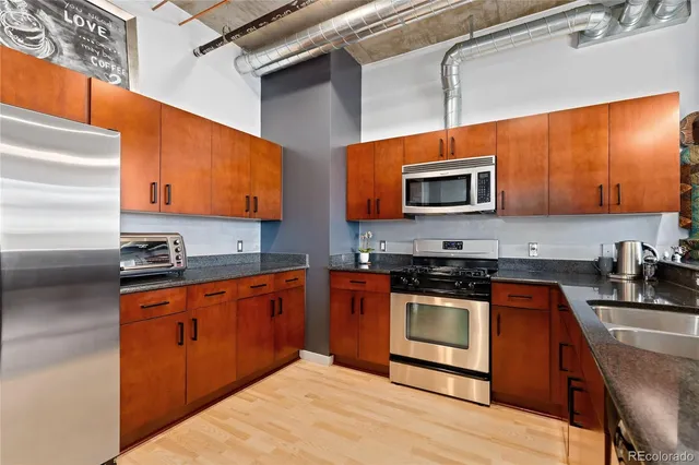 a kitchen with stainless steel appliances granite countertop a stove a sink and a microwave