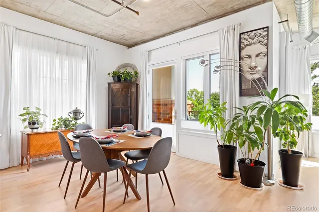 a dining room with furniture and potted plants