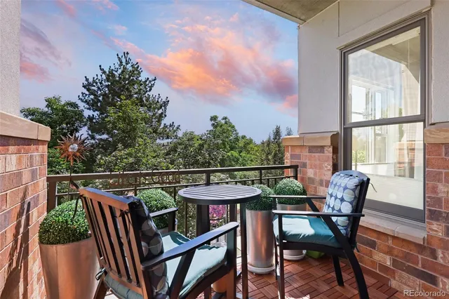 a balcony with wooden floor table and chairs