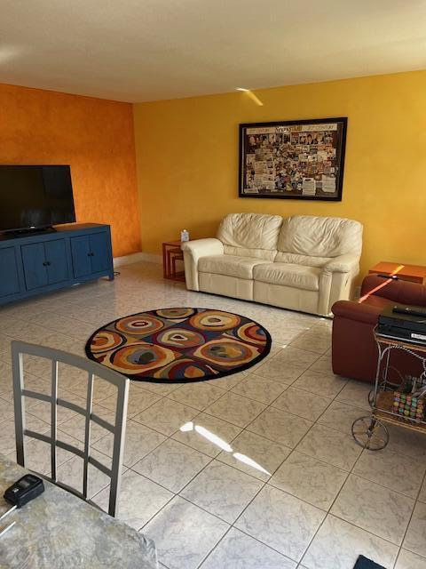 80 Valencia C, Unit D Delray Beach, FL 33446 - Photo 1 of 14 a living room with furniture and a flat screen tv
