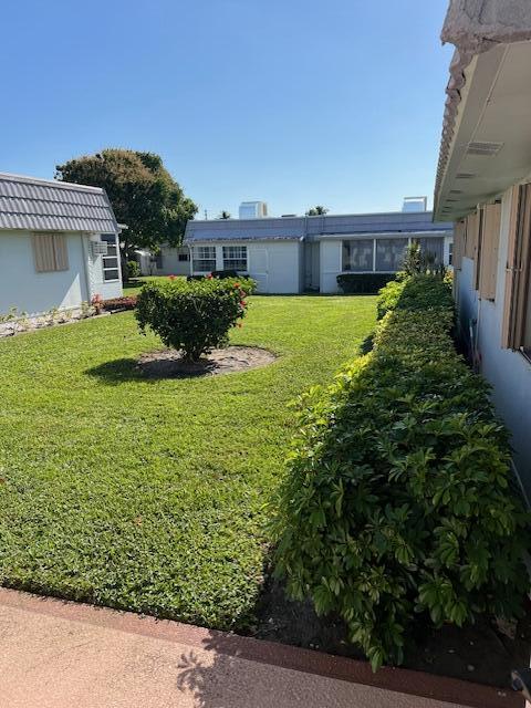 80 Valencia C, Unit D Delray Beach, FL 33446 - Photo 11 of 14 a view of house with a garden