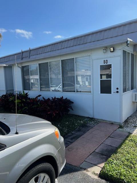 80 Valencia C, Unit D Delray Beach, FL 33446 - Photo 13 of 14 a front view of a house with parking space