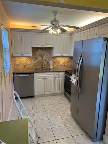 a kitchen with stainless steel appliances granite countertop a refrigerator and a sink