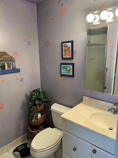 80 Valencia C, Unit D Delray Beach, FL 33446 - Photo 6 of 14 a bathroom with a toilet sink and mirror