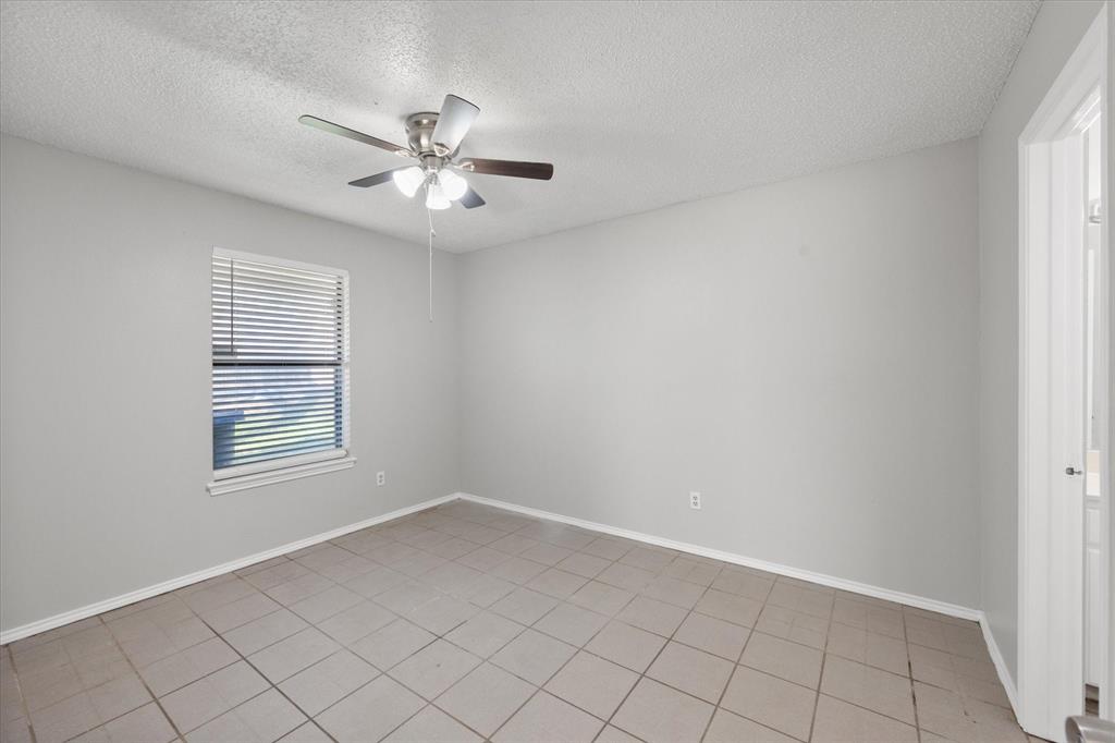 5821 Mansfield Road Arlington, TX 76017 - Photo 19 of 24 an empty room with windows and fan