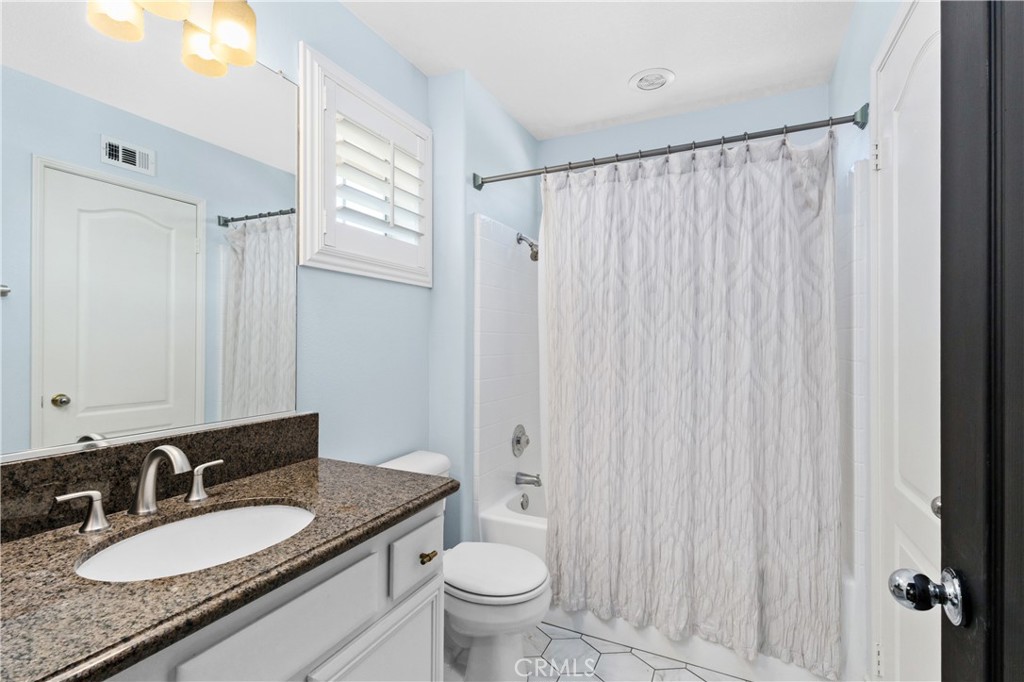 13668 Kingsbridge Street Westminster, CA 92683 - Photo 14 of 36 a bathroom with a granite countertop sink toilet and a mirror