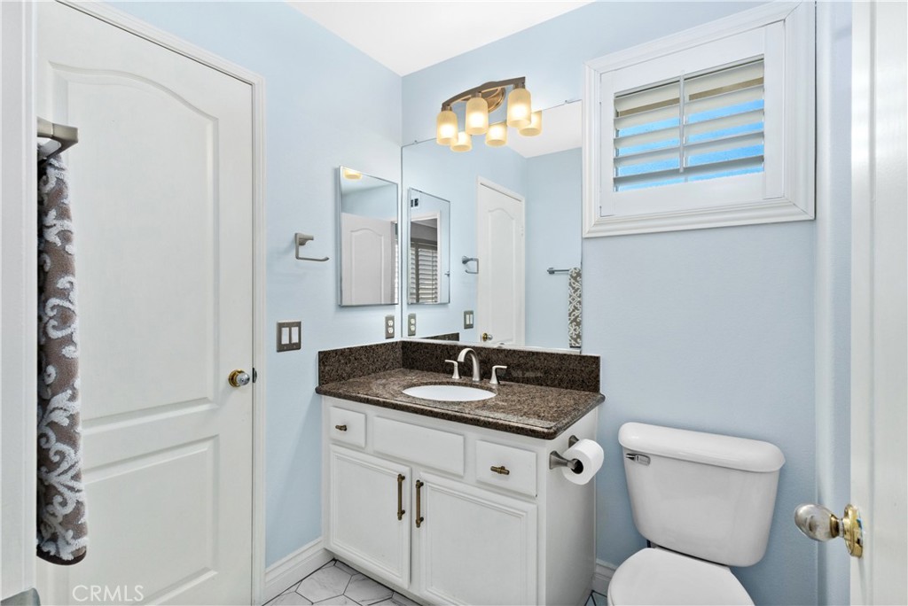 13668 Kingsbridge Street Westminster, CA 92683 - Photo 15 of 36 a bathroom with a granite countertop sink and a toilet