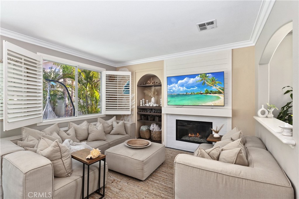 13668 Kingsbridge Street Westminster, CA 92683 - Photo 9 of 36 a living room with furniture a fireplace and a flat screen tv