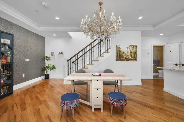 a living room with furniture a chandelier and wooden floor