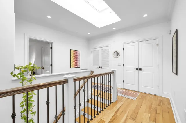 a view of a hallway with wooden floor and windows