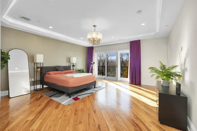 a spacious bedroom with a large bed and a chandelier