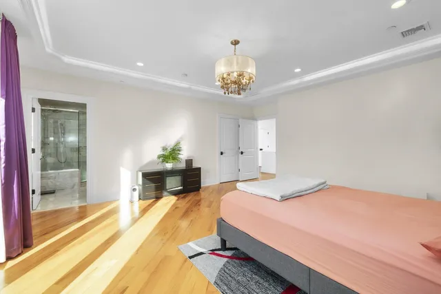 a spacious bedroom with a bed and a chandelier