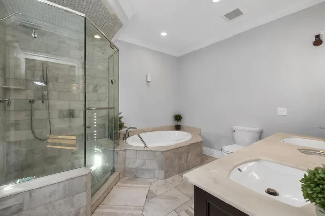 a bathroom with a sink a toilet and shower