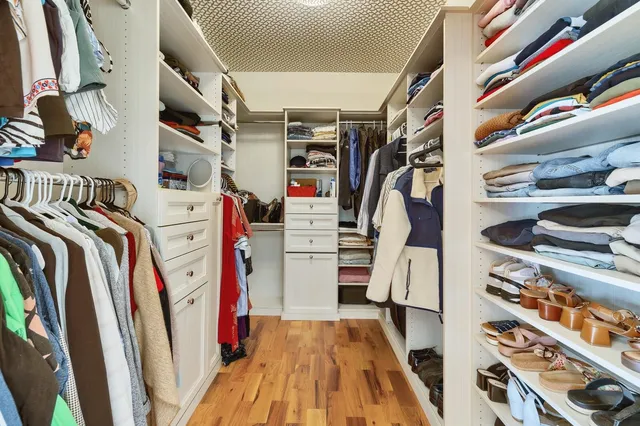 a view of walk in closet with clothes and shoes