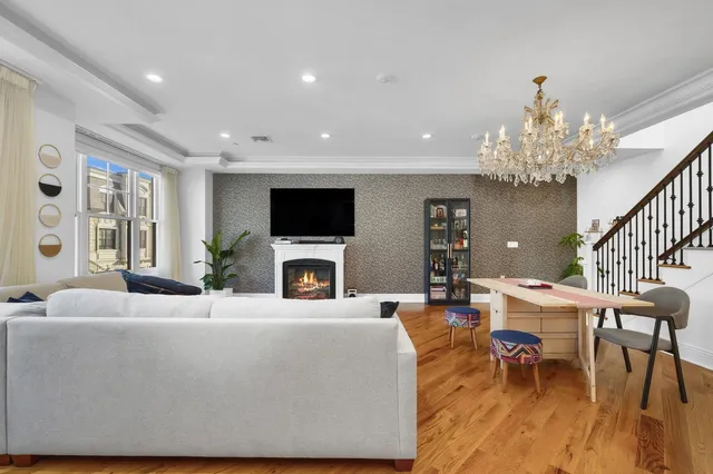 a living room with furniture a chandelier and a flat screen tv