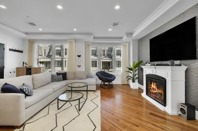 a living room with furniture a flat screen tv and a fireplace