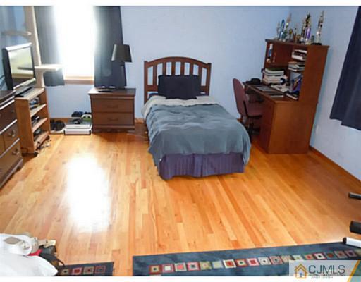 150 Kimberly Road Colonia, NJ 07067 - Photo 4 of 10 a bedroom with a bed and wooden floor
