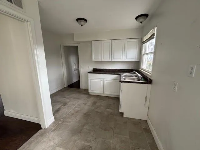 a kitchen with white cabinets and white appliances