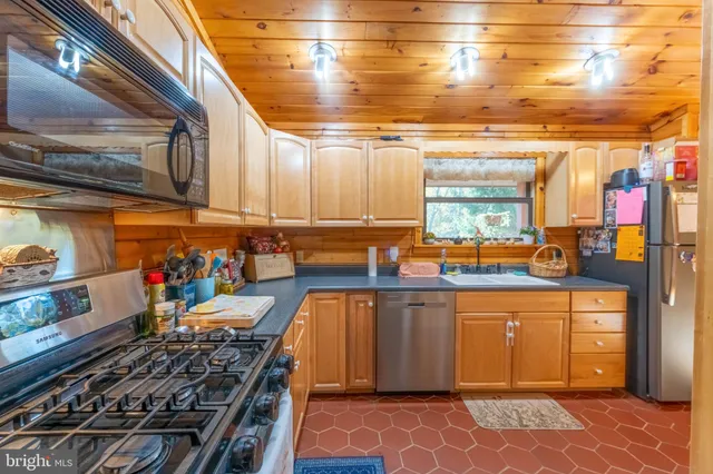 a kitchen with stainless steel appliances a stove and more cabinets