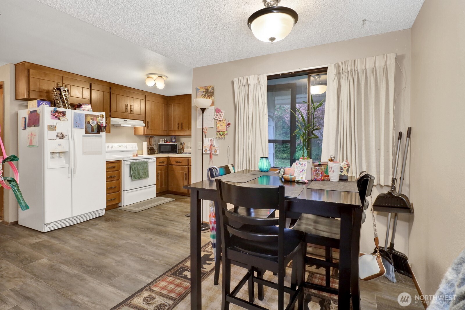 908 Liberty Street Lynden, WA 98264 - Photo 22 of 27 a kitchen with stainless steel appliances kitchen island granite countertop a dining table chairs and a refrigerator