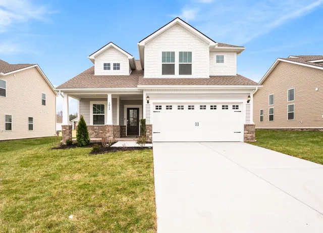 a view of a white house with a big yard and large trees