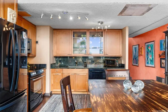 a kitchen with stainless steel appliances granite countertop a stove a sink and a refrigerator