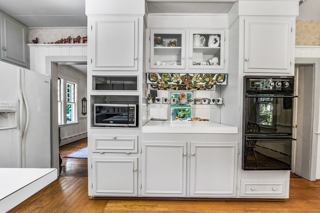 216 Spring Street Marshfield, MA 02050 - Photo 11 of 36 a kitchen with stainless steel appliances white cabinets and wooden floor