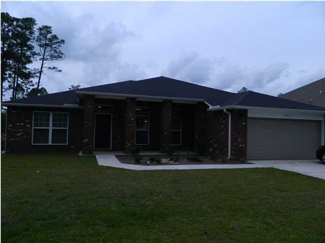 4611 Hermosa Road Crestview, FL 32539 - Photo 1 of 19 a front view of a house with a yard garden and trees