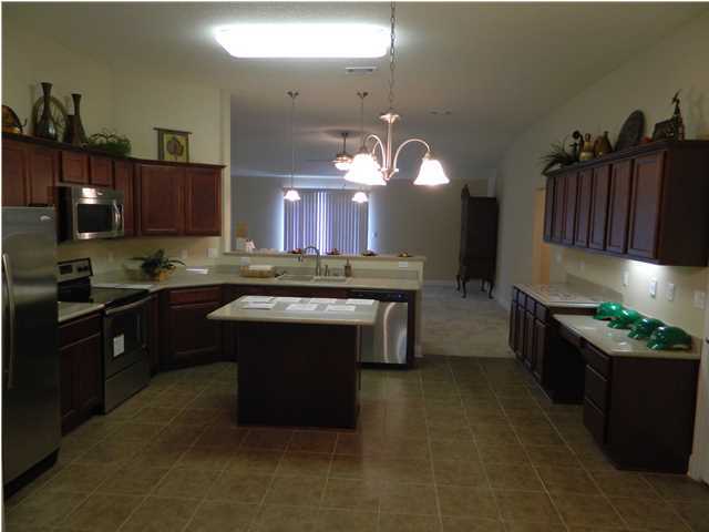 4611 Hermosa Road Crestview, FL 32539 - Photo 18 of 19 a kitchen with kitchen island granite countertop a stove top oven and cabinets