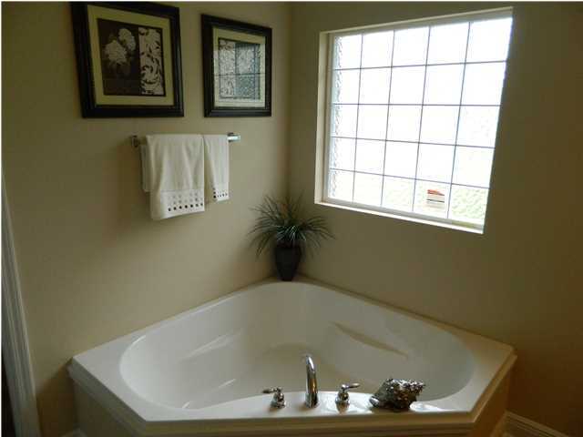 4611 Hermosa Road Crestview, FL 32539 - Photo 7 of 19 a bath tub sitting in a bathroom next to a window