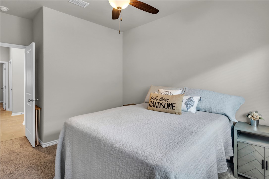 1033 Ocean Breeze Portland, TX 78374 - Photo 13 of 38 a bedroom with a bed and a chandelier