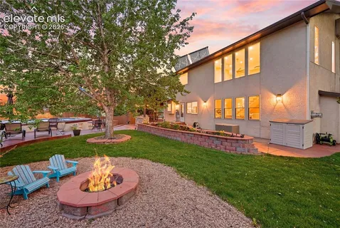 a view of a backyard with table and chairs and a fire pit