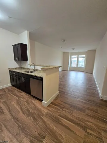 a kitchen with stainless steel appliances granite countertop a sink counter space and wooden floor