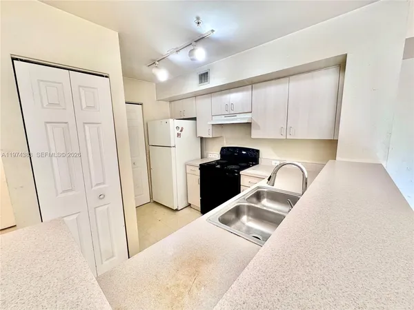 a kitchen with stainless steel appliances a refrigerator sink and cabinets