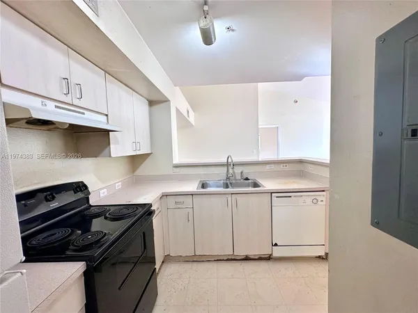 a kitchen with granite countertop a sink a stove and cabinets