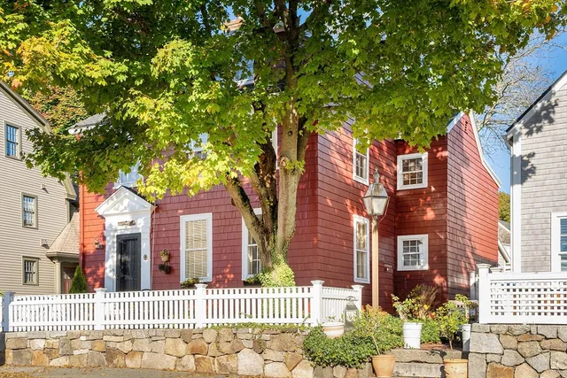 a view of a brick house with a large tree