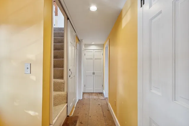 a view of a hallway with wooden floor and entryway