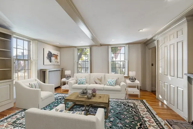 a living room with furniture large window and wooden floor