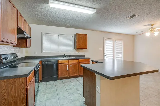 a kitchen with stainless steel appliances granite countertop a sink stove and cabinets