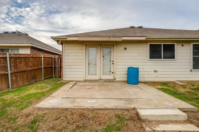a view of a house with backyard and wooden fence
