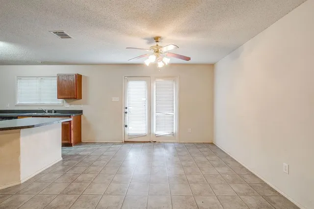 a view of kitchen with granite countertop cabinets and window