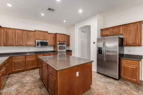 a kitchen with stainless steel appliances granite countertop a stove a sink dishwasher and a refrigerator