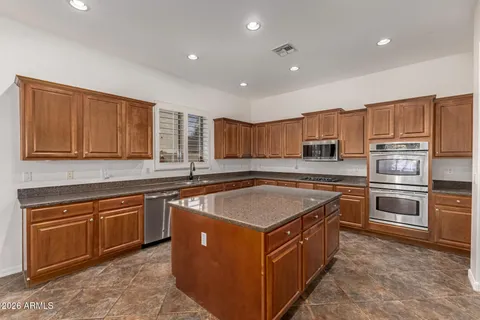 a kitchen with stainless steel appliances granite countertop a sink stove and cabinets